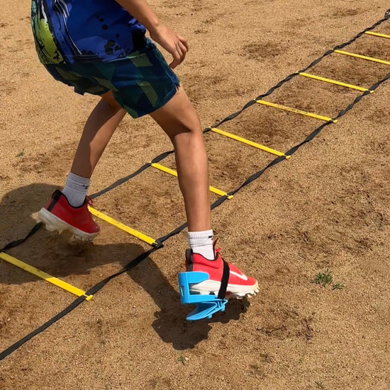 Child running on a agility ladder on a sports field